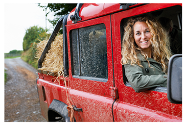 image of a Jeep pickup truck driving through mud and gravel with woman looking out the passenger window with her arm resing on the open window frame